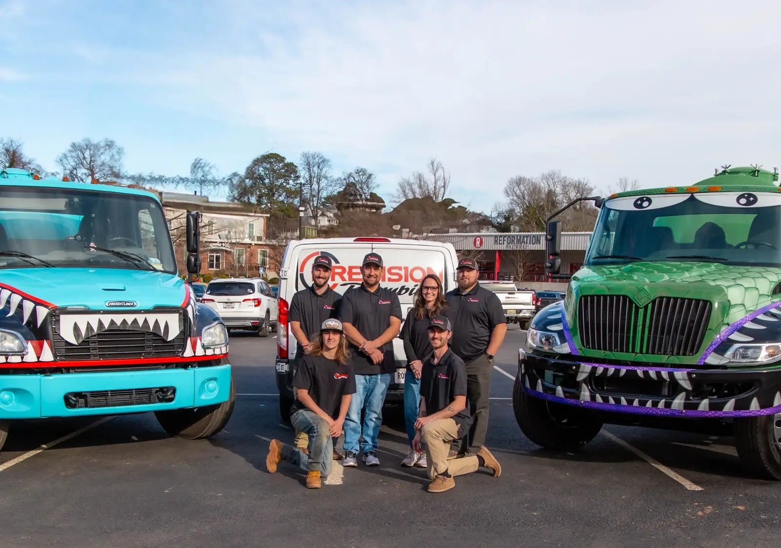 The Precision Plumbing & Septic crew with their fleet in downtown Canton, Georgia