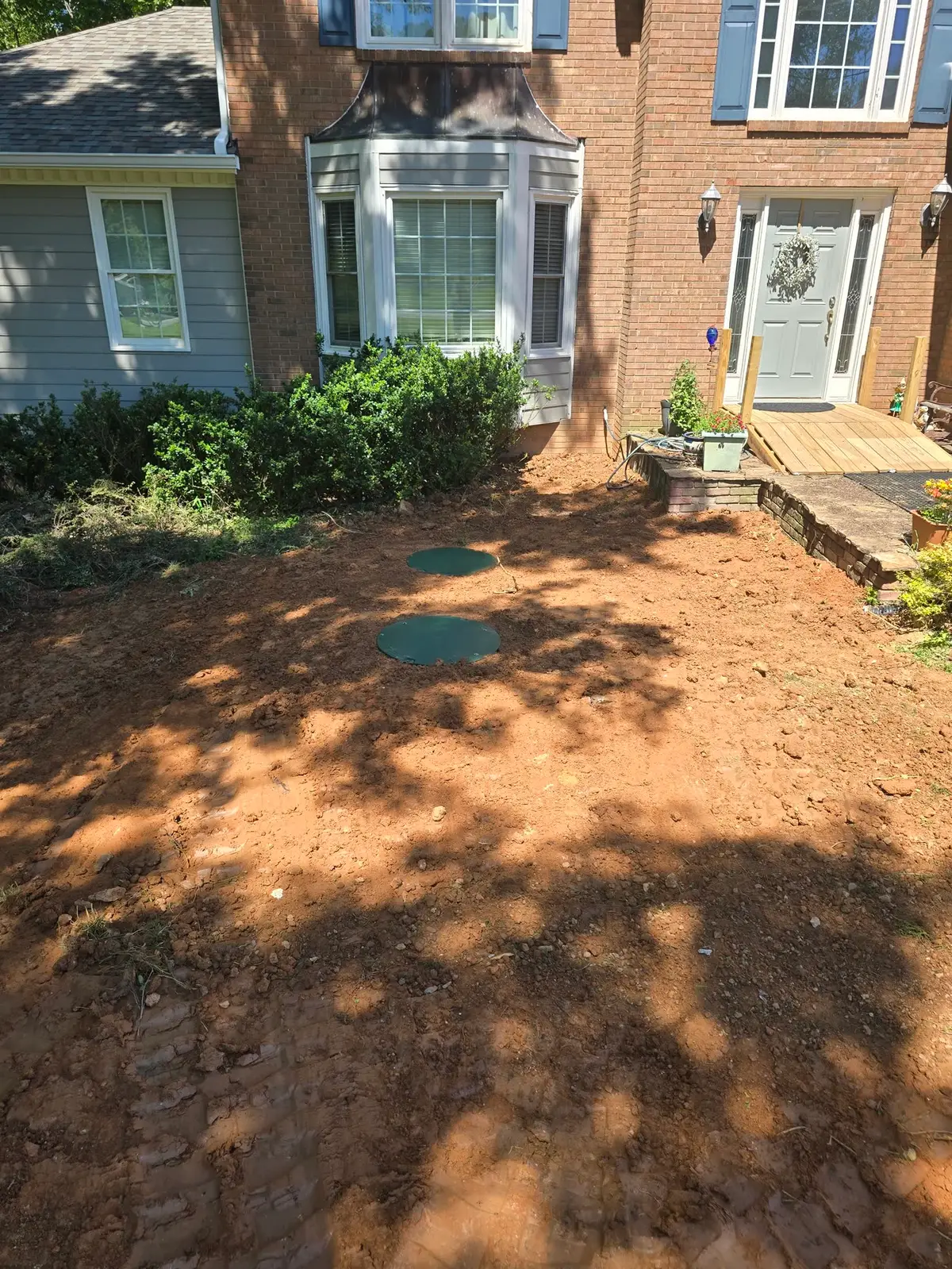 After — same yard finished, lids at grade and ground restored