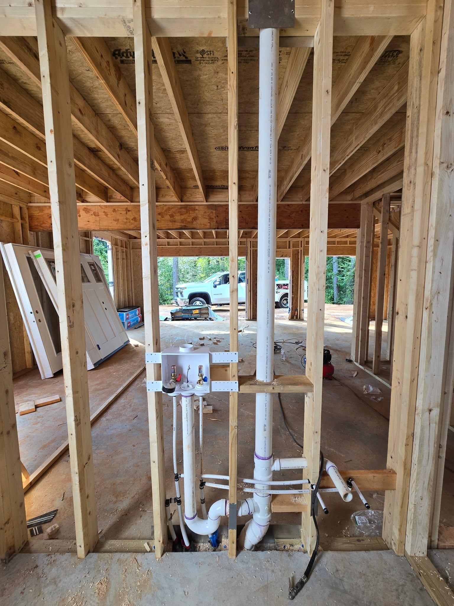 Laundry box, PVC drain, and PEX supply lines rough-in on a new-home wall